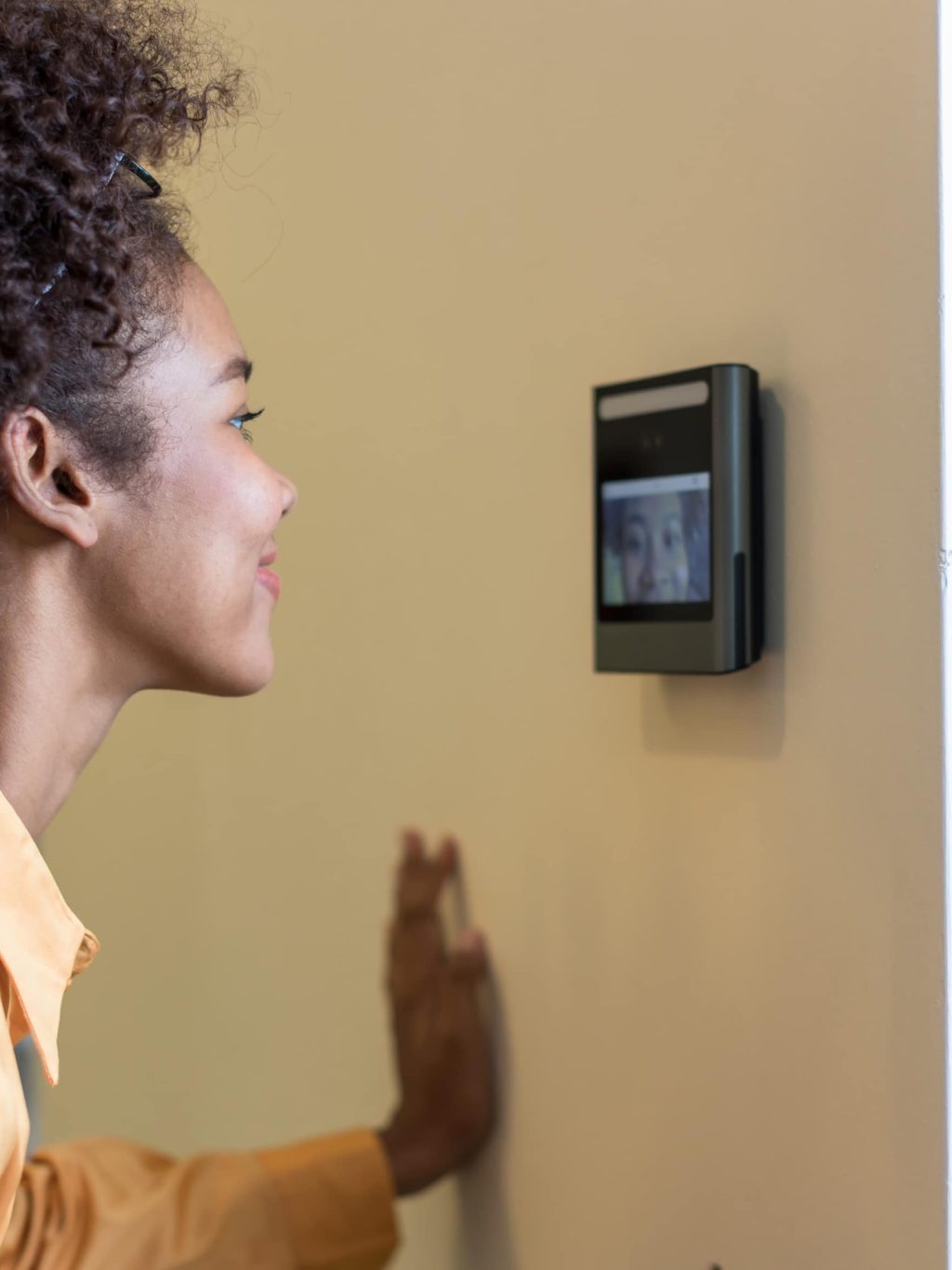 Woman using a wall-mounted security panel